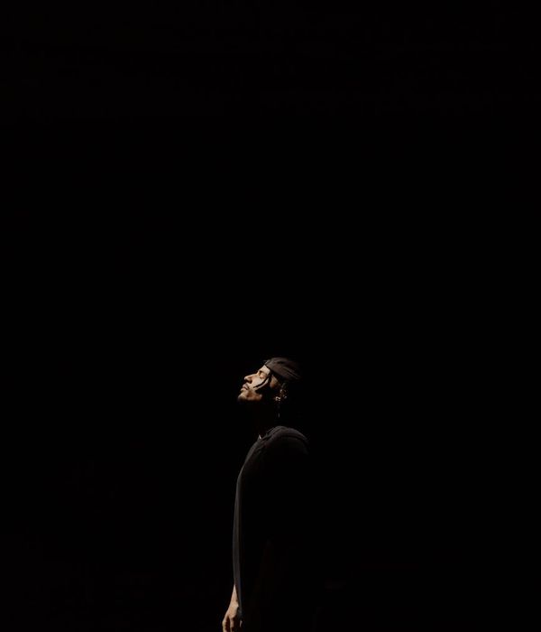 Focused man in a meditative pose after a workout, surrounded by calm ambiance.